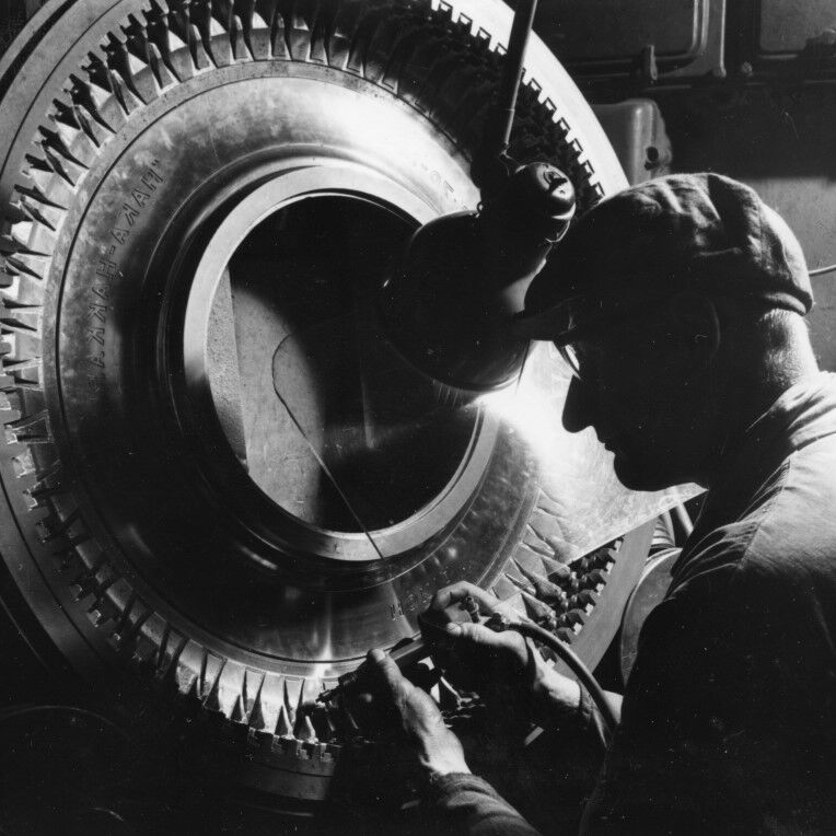 Person inspecting a tire closely.